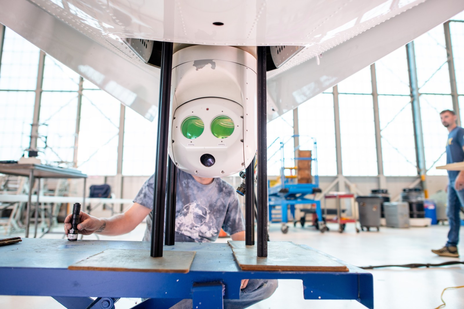 The retractable optical communications terminal protruding from the belly of NASA's PC-12 research aircraft in the hangar